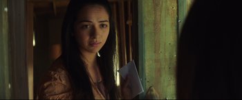 Movie still from “Truth or Dare” (2018), directed by Jeff Wadlow – A young woman holding a piece of paper in front of a window; Close Up shot, Over the shoulder angle