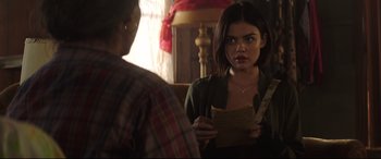 Movie still from “Truth or Dare” (2018), directed by Jeff Wadlow – A woman holding a piece of paper in front of a man; Close Up shot, Over the shoulder angle
