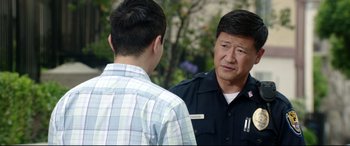 Movie still from “Truth or Dare” (2018), directed by Jeff Wadlow – A man in a police uniform talking to a young man; Close Up shot, Over the shoulder angle