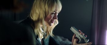 Movie still from “Truth or Dare” (2018), directed by Jeff Wadlow – A woman looking at a cell phone while wearing a leather jacket; Close Up shot, Over the shoulder angle