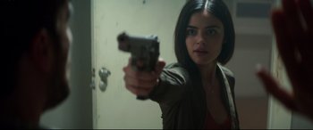 Movie still from “Truth or Dare” (2018), directed by Jeff Wadlow – A woman is holding a gun in a room; Close Up shot, High angle