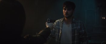 Movie still from “Truth or Dare” (2018), directed by Jeff Wadlow – A man holding a gun in a dark room; Close Up shot, Over the shoulder angle