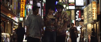 Movie still from “Truth or Dare” (2018), directed by Jeff Wadlow – A group of people standing on the street looking at a cell phone; Medium shot, Low angle