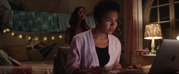 Movie still from “Truth or Dare” (2018), directed by Jeff Wadlow – A woman sitting in front of another woman in a room; Medium shot, Over the shoulder angle