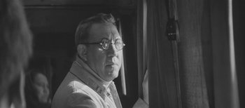 An older man wearing glasses looking at the camera