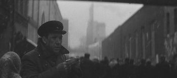 A man in a hat is looking at his cell phone