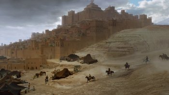 Movie still from “Game of Thrones” (2011), created by D.B. Weiss – A group of people riding horses near a castle; Extreme Wide shot, High angle