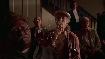 Movie still from “Twilight Zone: The Movie” (1983), directed by Steven Spielberg – An old man blowing bubbles in front of a group of people; Close Up shot, Low angle