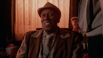 Movie still from “Twilight Zone: The Movie” (1983), directed by Steven Spielberg – An older man wearing a hat and a tie; Close Up shot, Low angle