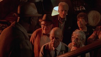 Movie still from “Twilight Zone: The Movie” (1983), directed by Steven Spielberg – A group of men and women standing next to each other on a train; Medium shot, High angle