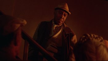 Movie still from “Twilight Zone: The Movie” (1983), directed by Steven Spielberg – An older man wearing a hat and a sweater; Medium shot, Low angle