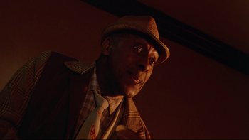 Movie still from “Twilight Zone: The Movie” (1983), directed by Steven Spielberg – A person wearing a suit and hat; Close Up shot, Low angle