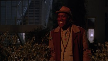 Movie still from “Twilight Zone: The Movie” (1983), directed by Steven Spielberg – An older man wearing a hat and a jacket smiling; Medium shot, Low angle