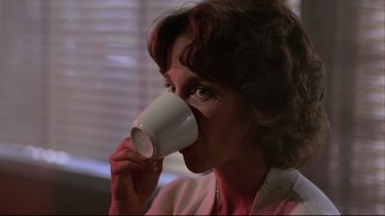 Movie still from “Twilight Zone: The Movie” (1983), directed by Steven Spielberg – A woman is drinking a cup of coffee; Close Up shot, Over the shoulder angle