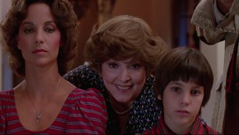 Movie still from “Twilight Zone: The Movie” (1983), directed by Steven Spielberg – A woman and two boys posing for a picture; Close Up shot, Low angle