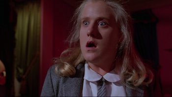 Movie still from “Twilight Zone: The Movie” (1983), directed by Steven Spielberg – A woman with long blonde hair wearing a suit and tie; Close Up shot, Low angle