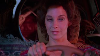 Movie still from “Twilight Zone: The Movie” (1983), directed by Steven Spielberg – A woman sitting in a car holding a steering wheel; Close Up shot, Low angle