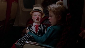 Movie still from “Twilight Zone: The Movie” (1983), directed by Steven Spielberg – A girl sitting on a seat holding a doll; Close Up shot, High angle