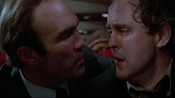 Movie still from “Twilight Zone: The Movie” (1983), directed by Steven Spielberg – Two men in suits are facing one another; Close Up shot, Low angle