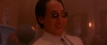 Movie still from “Twin Dragons” (1992), directed by Ringo Lam – A person wearing a suit and sunglasses; Close Up shot, Low angle