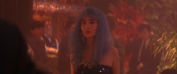 Movie still from “Twin Dragons” (1992), directed by Ringo Lam – A woman with blue hair is posing for a picture; Close Up shot, Over the shoulder angle