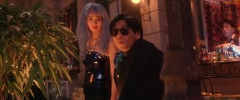 Movie still from “Twin Dragons” (1992), directed by Ringo Lam – A man and a woman standing next to each other in front of a building; Medium shot, Low angle