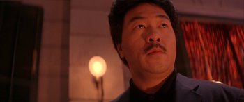 Movie still from “Twin Dragons” (1992), directed by Ringo Lam – A person wearing a black shirt; Close Up shot, Low angle