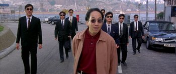 Movie still from “Twin Dragons” (1992), directed by Ringo Lam – A group of men walking down a street; Medium shot, High angle