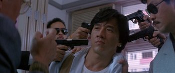 Movie still from “Twin Dragons” (1992), directed by Ringo Lam – A man getting his hair cut by another man holding a gun; Close Up shot, Low angle