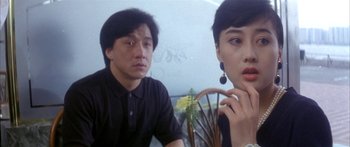 Movie still from “Twin Dragons” (1992), directed by Ringo Lam – A man and a woman sitting next to each other; Close Up shot, Over the shoulder angle