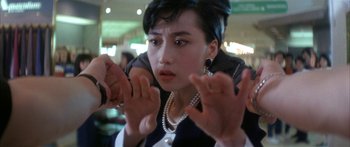 Movie still from “Twin Dragons” (1992), directed by Ringo Lam – A woman with her hands up in the air; Close Up shot, High angle