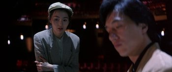 Movie still from “Twin Dragons” (1992), directed by Ringo Lam – A woman and a man are sitting on a stage; Medium shot, Over the shoulder angle