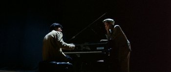 Movie still from “Twin Dragons” (1992), directed by Ringo Lam – Two people sitting at a piano in the dark; Medium shot, High angle