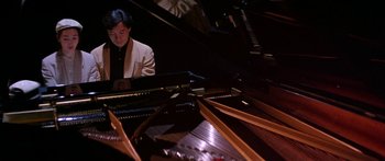 Movie still from “Twin Dragons” (1992), directed by Ringo Lam – A man sitting in front of a grand piano; Medium shot, High angle