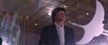 Movie still from “Twin Dragons” (1992), directed by Ringo Lam – A man in a suit and tie looking up; Medium shot, Low angle
