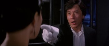 Movie still from “Twin Dragons” (1992), directed by Ringo Lam – A man wearing a white glove pointing at a woman; Close Up shot, Over the shoulder angle