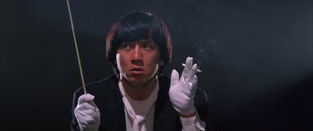 Movie still from “Twin Dragons” (1992), directed by Ringo Lam – A man in a black jacket and white gloves smoking a cigarette; Close Up shot, Low angle