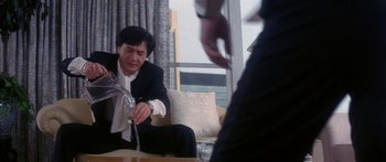 Movie still from “Twin Dragons” (1992), directed by Ringo Lam – A man in a suit and tie holding a wine glass; Medium shot, Low angle
