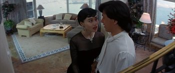 Movie still from “Twin Dragons” (1992), directed by Ringo Lam – A man and a woman talking in a living room; Medium shot, Over the shoulder angle