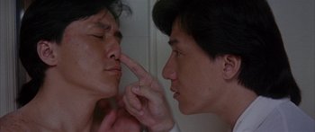 Movie still from “Twin Dragons” (1992), directed by Ringo Lam – A man touching his nose while looking into a bathroom mirror; Close Up shot, Over the shoulder angle