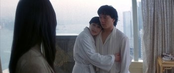 Movie still from “Twin Dragons” (1992), directed by Ringo Lam – A man and a woman in white robes hugging each other; Medium shot, Over the shoulder angle