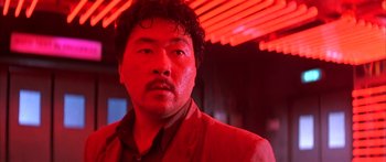 Movie still from “Twin Dragons” (1992), directed by Ringo Lam – A person wearing a suit and tie; Close Up shot, Low angle