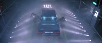 Movie still from “Twin Dragons” (1992), directed by Ringo Lam – Two men pushing a car through a puddle of water; Wide shot, High angle