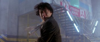 Movie still from “Twin Dragons” (1992), directed by Ringo Lam – A man in a black jacket is holding a white tie; Close Up shot, Low angle