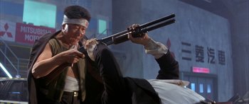 Movie still from “Twin Dragons” (1992), directed by Ringo Lam – A man holding a rifle in his hand while another man holds it up; Medium shot, Low angle