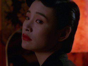 Movie still from “Twin Peaks” (1990), created by David Lynch – A person wearing a black shirt; Close Up shot, Over the shoulder angle
