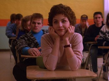 Movie still from “Twin Peaks” (1990), created by David Lynch – A woman sitting in front of a group of people in a classroom; Medium shot, Over the shoulder angle