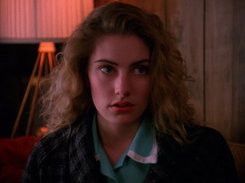 Movie still from “Twin Peaks” (1990), created by David Lynch – A person with curly hair; Close Up shot, Over the shoulder angle