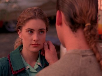 Movie still from “Twin Peaks” (1990), created by David Lynch – A man touching the ear of a young woman in front of a mirror; Close Up shot, Over the shoulder angle