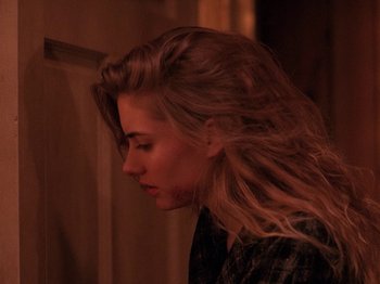 Movie still from “Twin Peaks” (1990), created by David Lynch – A woman with long blonde hair is looking down; Close Up shot, Over the shoulder angle
